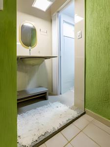 ein Badezimmer mit Spiegel und Fernseher an der Wand in der Unterkunft Casinha p/5 Charmosa in Volta Redonda