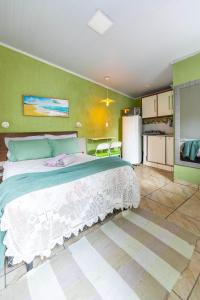 een slaapkamer met een groot bed en een koelkast bij Studio p/3 Climatizado in Volta Redonda