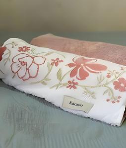 een kussen met bloemen erop zittend op een bed bij Studio p/3 Climatizado in Volta Redonda