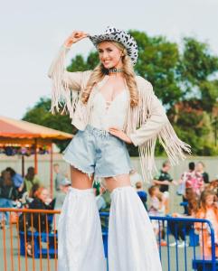 Una mujer con sombrero y pantalones cortos en un carnaval. en The Willerby Salsa, en Rhyl