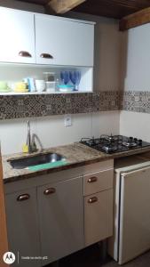 eine Küche mit Spüle und Herd in der Unterkunft Chalé Diamante c /AR in Volta Redonda