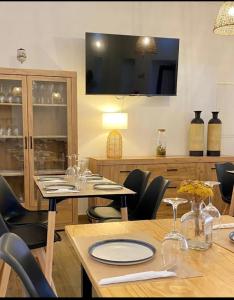 a dining room with a table and chairs and a television at Casa da Pedra - Alvados, Porto de Mós in Alvados