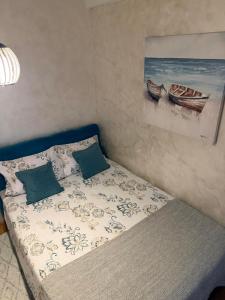 波扎雷瓦茨Apartman Odmor012的一张带两个枕头的床和墙上的绘画