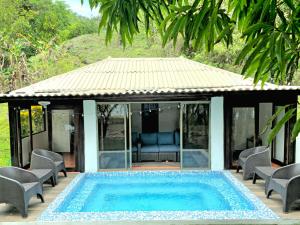 a villa with a swimming pool and a house at Bio-Cébaco Cabañas in Isla Cebaco 