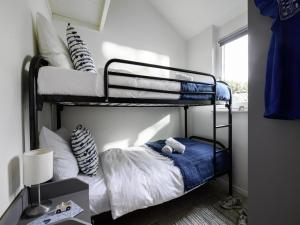 una camera da letto con due letti a castello e una finestra di Relaxing Waterfront Bungalow a Nieuw-Loosdrecht