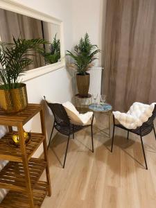 een woonkamer met stoelen, een tafel en een spiegel bij APPOVEL- Balkonové Studio in Olomouc