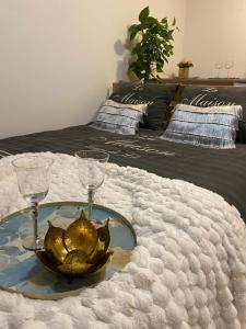 een tafel met twee glazen en een kom op een bed bij APPOVEL- Balkonové Studio in Olomouc