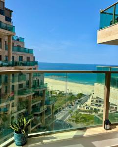 ein Blick auf den Strand vom Balkon eines Gebäudes in der Unterkunft Beach Suite Israel - Indoor Pool, Best View, Gym, Massage Chair, Spa ביץ סוייט ישראל - נוף ים מאלף, בריכה מקורה, כיסא מסאז, חדר כושר וספא in Aschkelon