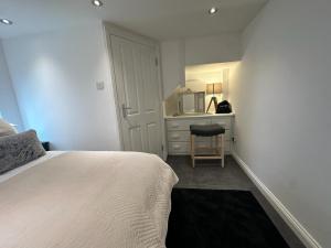 a bedroom with a bed and a desk with a chair at One bed Mews House in Northwood