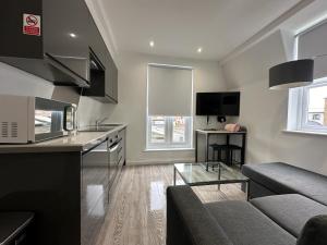 a kitchen and living room with a couch and a table at One bed Mews House in Northwood