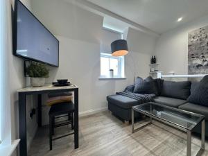 a living room with a couch and a flat screen tv at One bed Mews House in Northwood