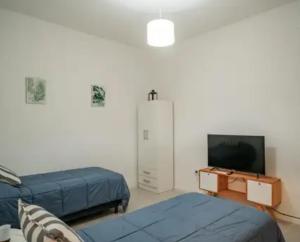 1 Schlafzimmer mit 2 Betten, einem TV und einer Kommode in der Unterkunft Hostel Suite DDT in Santa Fe