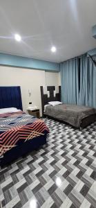 a bedroom with two beds and a checkered floor at Hotel gym club33 in Huancayo