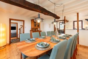a dining room with a wooden table and chairs at Zum Alten Kuhstall - Großes Landhaus mit XXL Sauna & Kamin in Lontzen