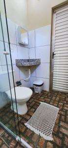 a bathroom with a toilet and a sink and a mirror at Hospedaria Oliveira - Santo Amaro do Maranhão in Queimada