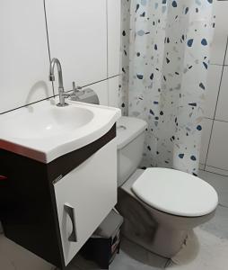 ein Badezimmer mit Waschbecken, Toilette und Duschvorhang in der Unterkunft Loft Aconchegante/Climatizado in Miguel Pereira