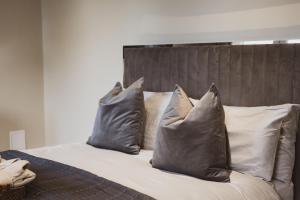 NetleyにあるHealth & Wellness House Hot Tub, Sauna & Ice Bathの枕が4つ置かれたベッド