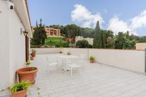 a patio with a white table and chairs on a balcony at Ciciliana in Valderice