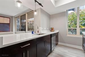 a kitchen with a sink and some windows at The Bernardin Gold Coast Luxury Apartments Near Magnificent Mile in Chicago +146 photos