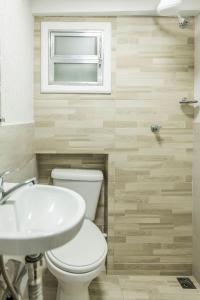 a bathroom with a toilet and a sink and a window at Micro Flat Compacto c/Banheiro in Volta Redonda +7 photos