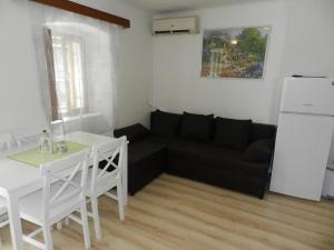 a living room with a black couch and a table at Apartment Protrka in Omiš +14 photos