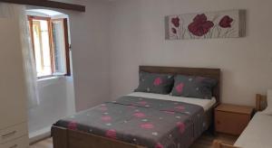 a bedroom with a bed with pink flowers on it at Apartment Protrka in Omiš