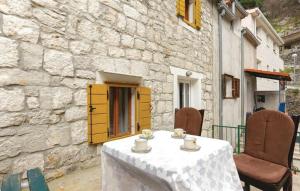 a table with cups and saucers on it next to a building at Apartment Protrka in Omiš