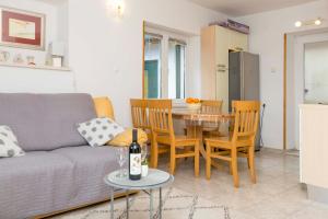 un soggiorno con un divano, un tavolo e delle sedie di House Frane a Supetar (San Pietro di Brazza)
