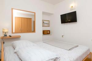 una camera con letto, specchio e TV di House Frane a Supetar (San Pietro di Brazza)