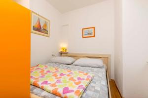 una camera da letto con un letto con una coperta colorata sopra di House Frane a Supetar (San Pietro di Brazza)