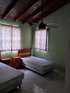 Lovely 3-bedroom house located near Oistins, close to beaches and Golf course في كرايست تشيرش: غرفة نوم بها سريرين ومروحة سقف