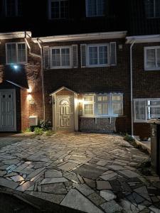 a brick house with a white door and a stone driveway at Spacious 5-Bed House in Chigwell - Grange Hill in Chigwell