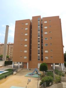 un gran edificio con un parque infantil delante de él en Apartamento Alicante, en Alicante