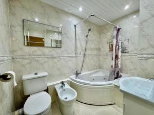 a bathroom with a toilet and a tub and a sink at Spacious 5-Bed House in Chigwell - Grange Hill in Chigwell +44 photos