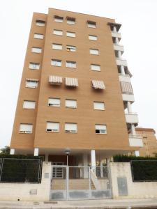 a tall brown building with white windows at Apartamento Alicante in Alicante