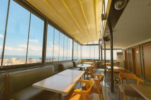 een restaurant met tafels en stoelen en grote ramen bij Kaya-Royal-Hotel Beyazit Istanbul All Tea And Coffee Are Complimentary And Available 24-7 On Our Sea View Terrace Restaurant in Istanbul +29 foto's