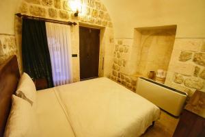 a bedroom with a bed in a room with a window at Mara Loya Konağı in Mardin +4 photos