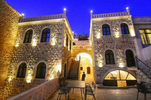 a person standing in front of a building with lights at Mara Loya Konağı in Mardin