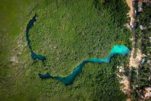 an overhead view of a river in a field at Beachfront 2BR Condo, Private Pool & Tankah Bay in Tulum