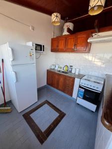 a kitchen with a white refrigerator and a stove at Temporario ARCO IRIS in Concordia