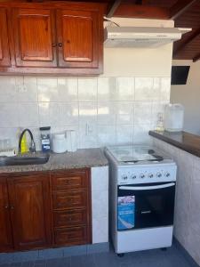 a kitchen with a stove and a sink at Temporario ARCO IRIS in Concordia