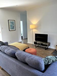 a living room with a couch and a flat screen tv at Happy Mountain House in Blackheath