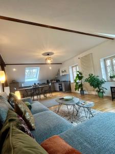 a living room with a couch and a table at l'Alchimiste - Appartement moderne avec jacuzzi in Bitche
