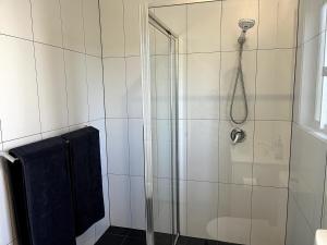 a bathroom with a shower with a glass door at Happy Mountain House in Blackheath