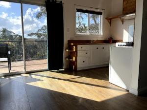 a kitchen with a large sliding glass door to a balcony at Happy Mountain House in Blackheath