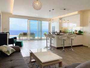 a living room and kitchen with a view of the ocean at Holiday Apartment Sunset Ocean in Ribeira Brava