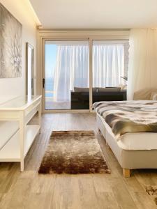 a bedroom with a bed and a desk and a window at Holiday Apartment Sunset Ocean in Ribeira Brava +49 photos