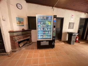 Habitación doble economica con Baño Privado في كوريكو: آلة بيع الصودا في غرفة بها مدفأة