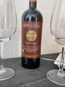 Habitación doble economica con Baño Privado في كوريكو: زجاجة من النبيذ للجلوس بجوار كأسين من النبيذ