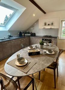 a kitchen with a table with dishes on it at l'Alchimiste - Appartement moderne avec jacuzzi in Bitche +10 photos